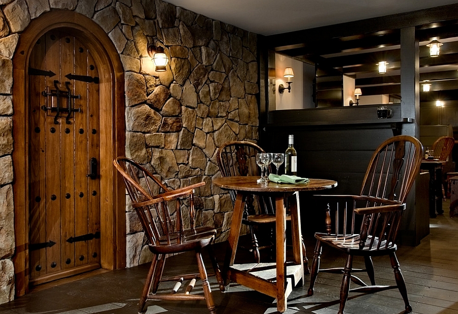 Stone wall and iron detailing give the basement makeover an authentic feel [Design: Crisp Architects]