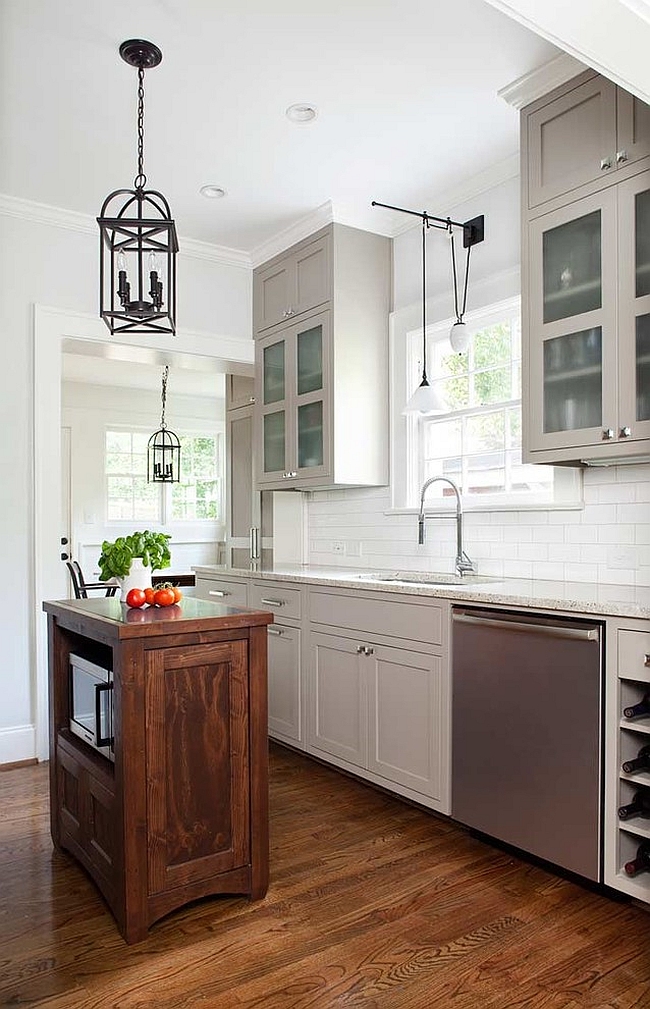 Transitional kitchen with a tiny island and beautiful lighting [Design: TerraCotta Studio]