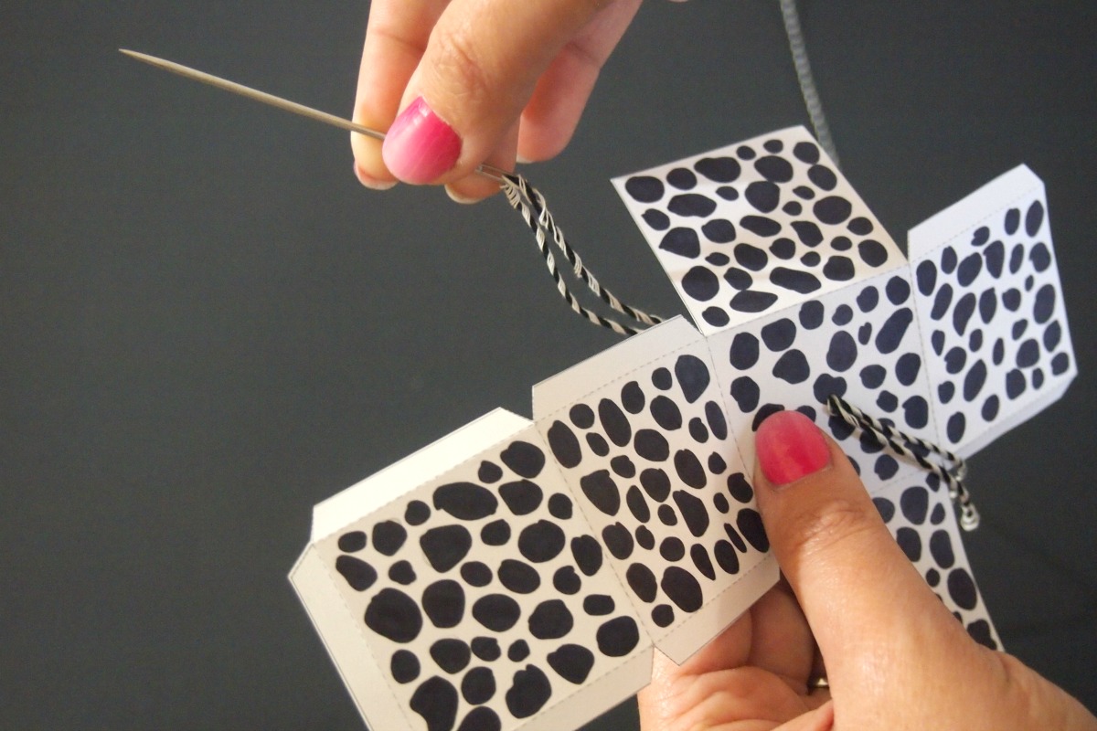 Use a needle to thread string through ornament