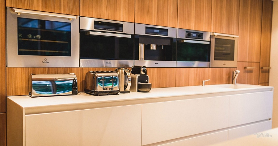 Warm wooden surfaces combined with sleek white kitchen counter