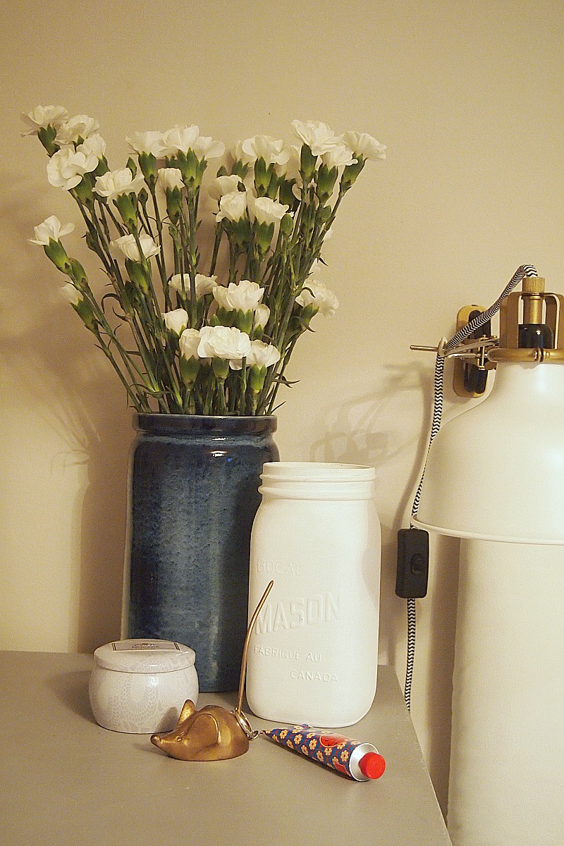 White mason jar styled on nightstand