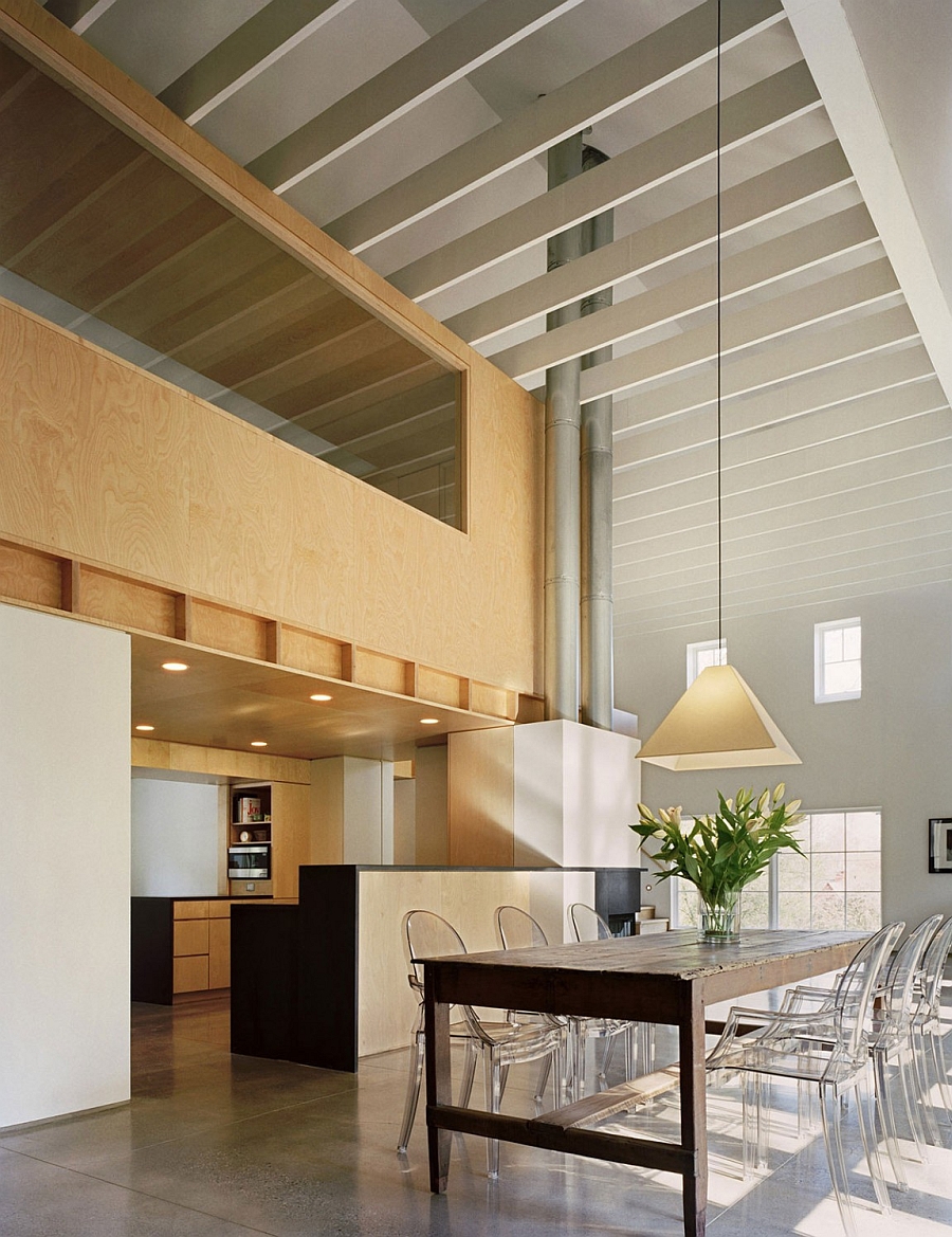 Acrylic chairs at the dining table add to the airy appeal of the loft-like barn house