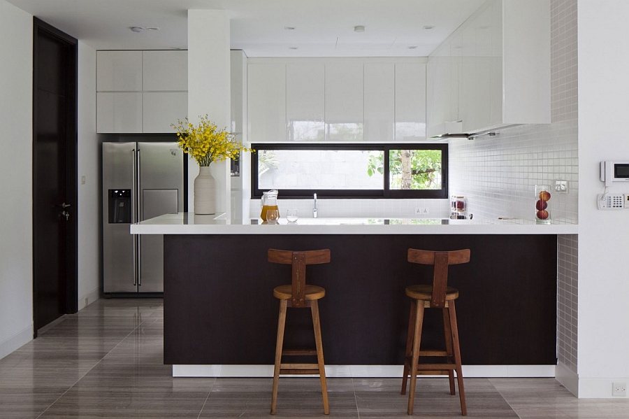 Dark kitchen island brings visual contrast to the white kitchen