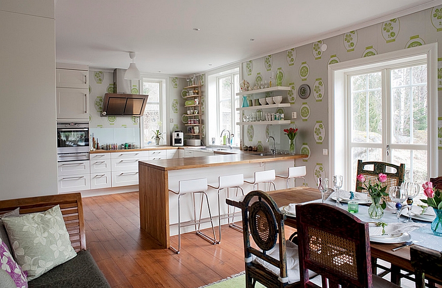 Elegant wallpaper unites the kitchen with the dining and living space visually