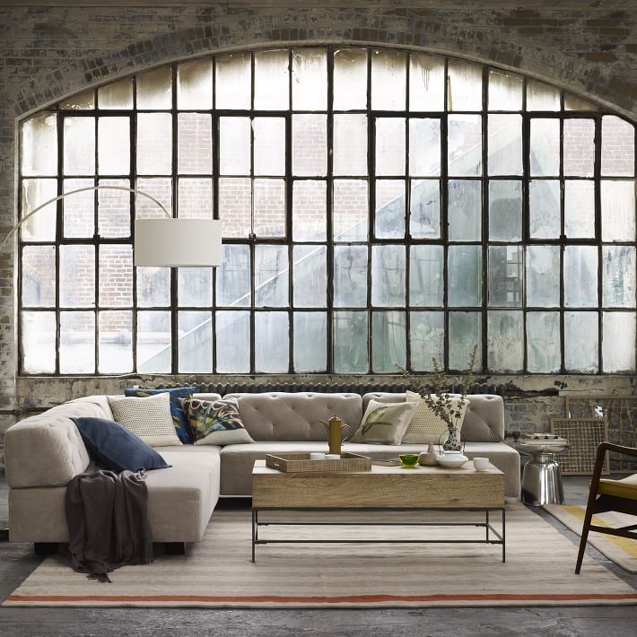 Tufted sectional sofa in a warehouse-style space