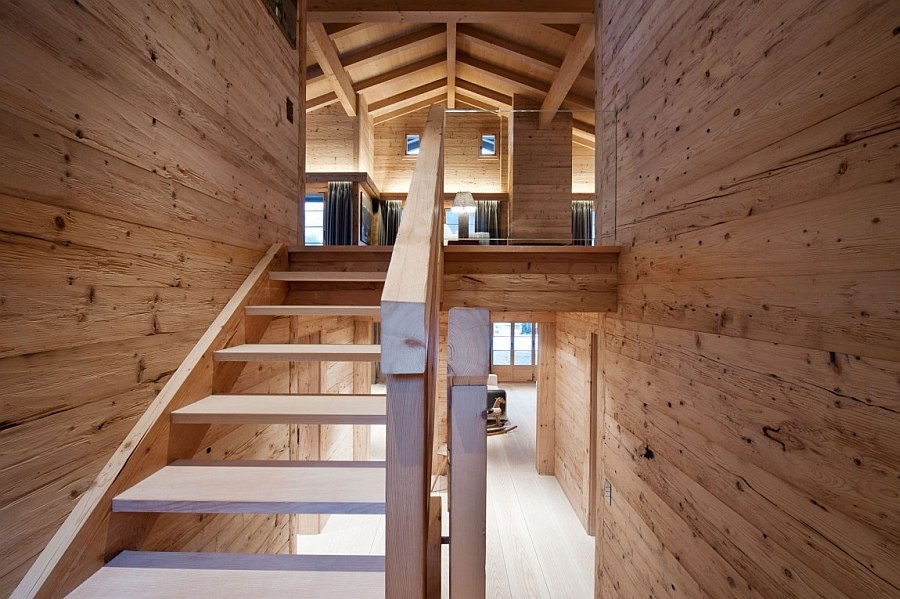 Wooden staircase inside the chalet leading to the top level