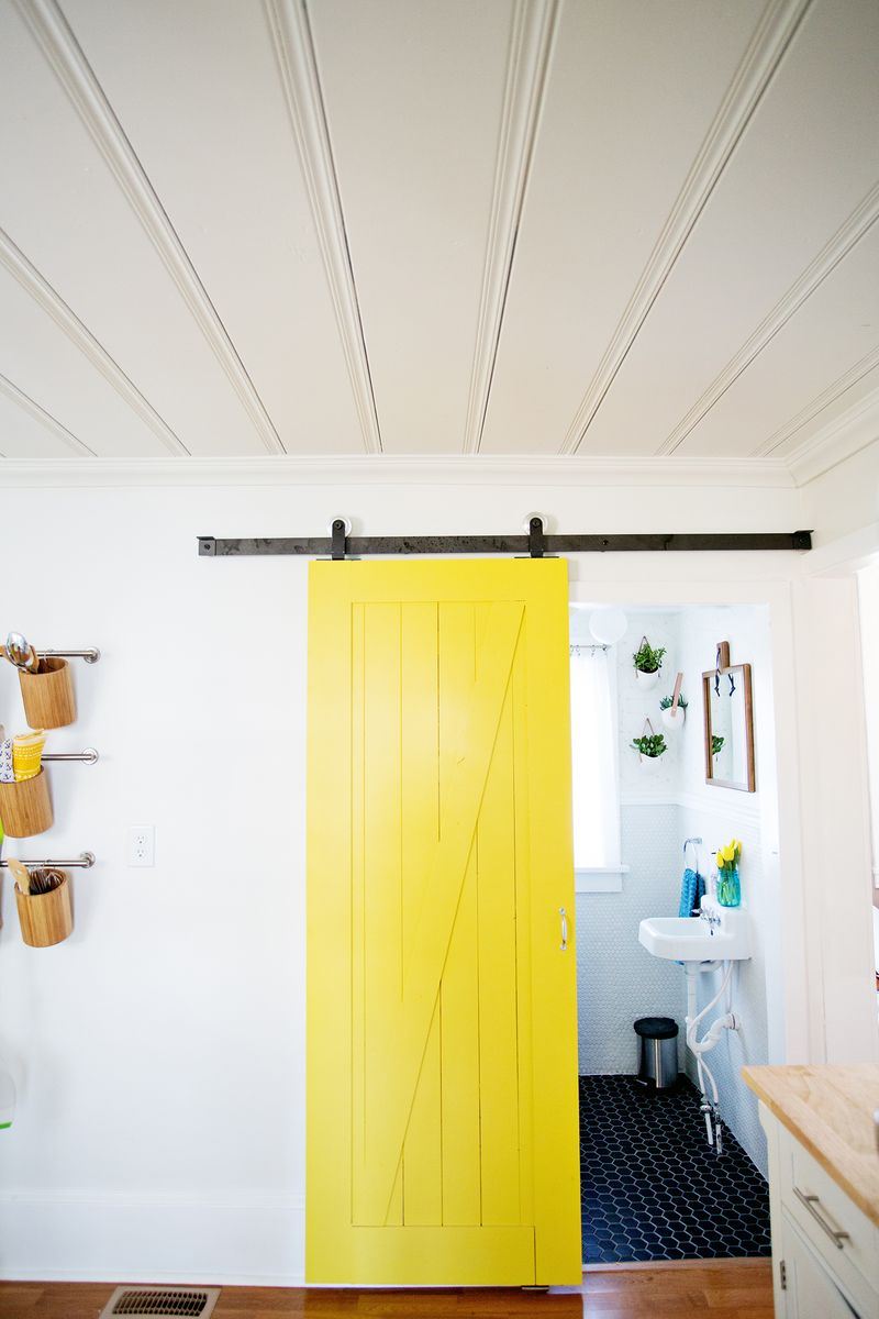 A sliding yellow barn door from A Beautiful Mess