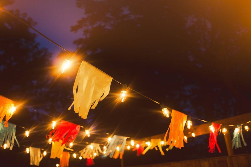 Colorful flags hang above a summertime porch party