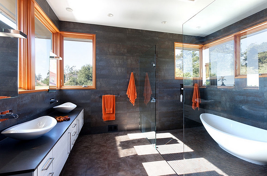 Dark bathroom walls offer the ideal background for the orange accents