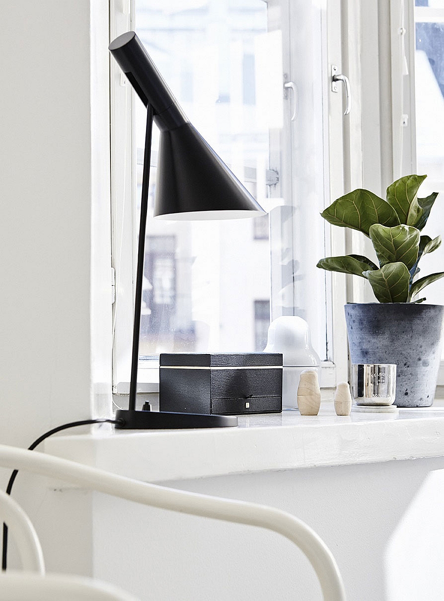 Dark bedside lamp stands out thanks to the all-white bedroom backdrop