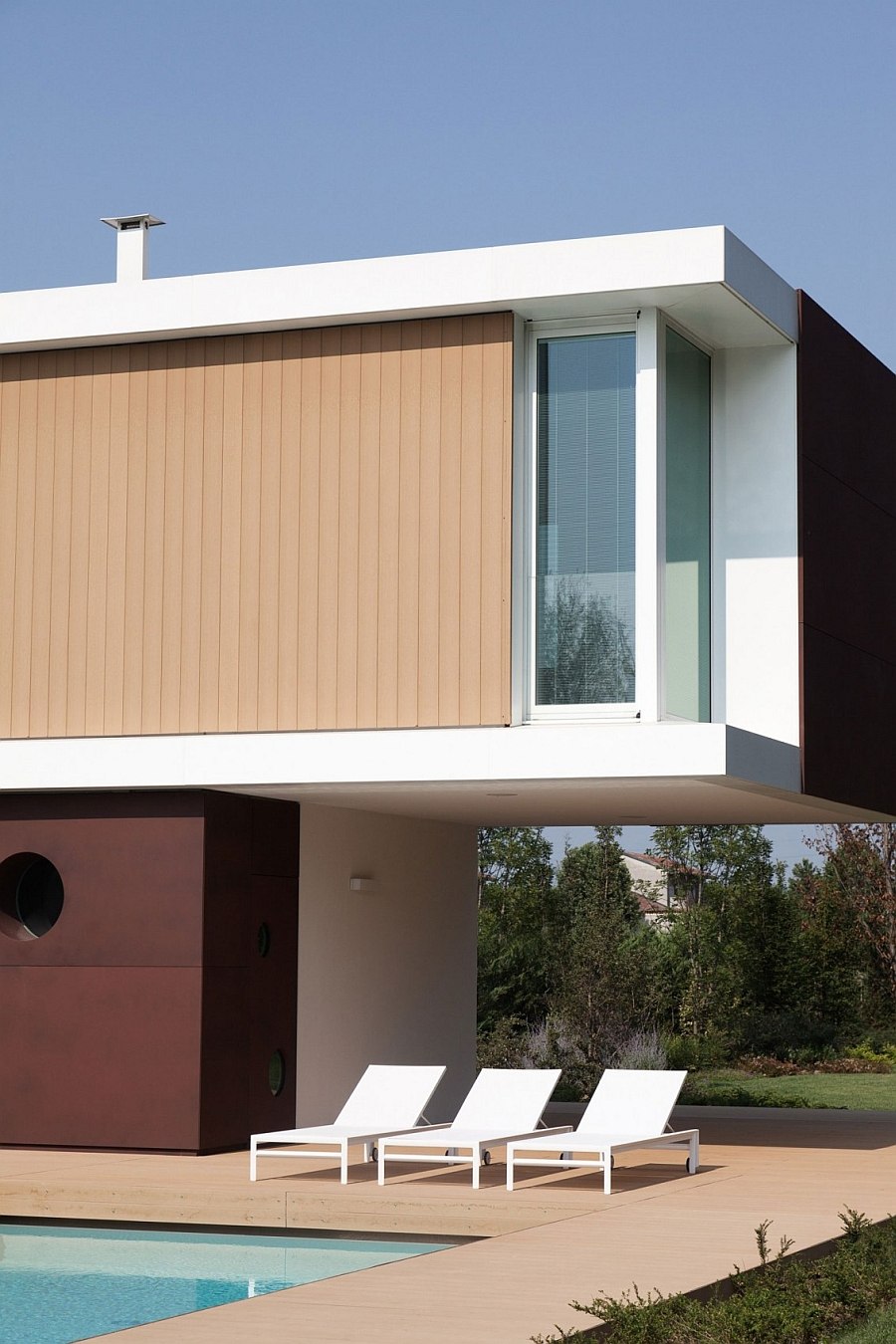 Exterior clad in white stucco, corten steel and wooden slats