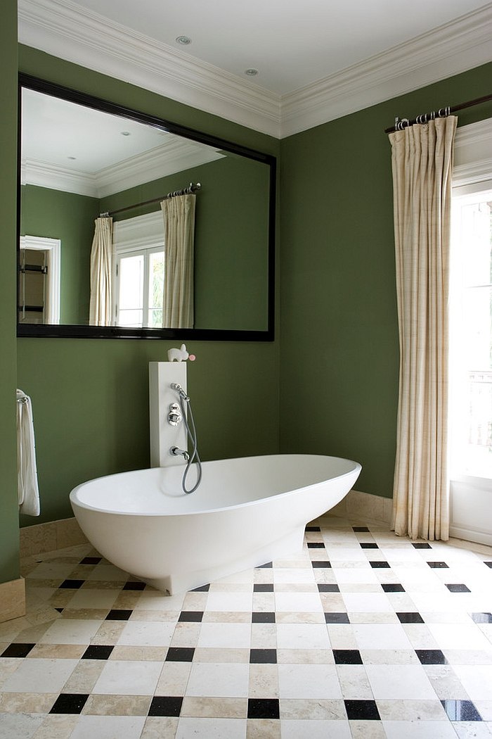 Green backdrop in the bathroom lets the white freestanding bathtub standout