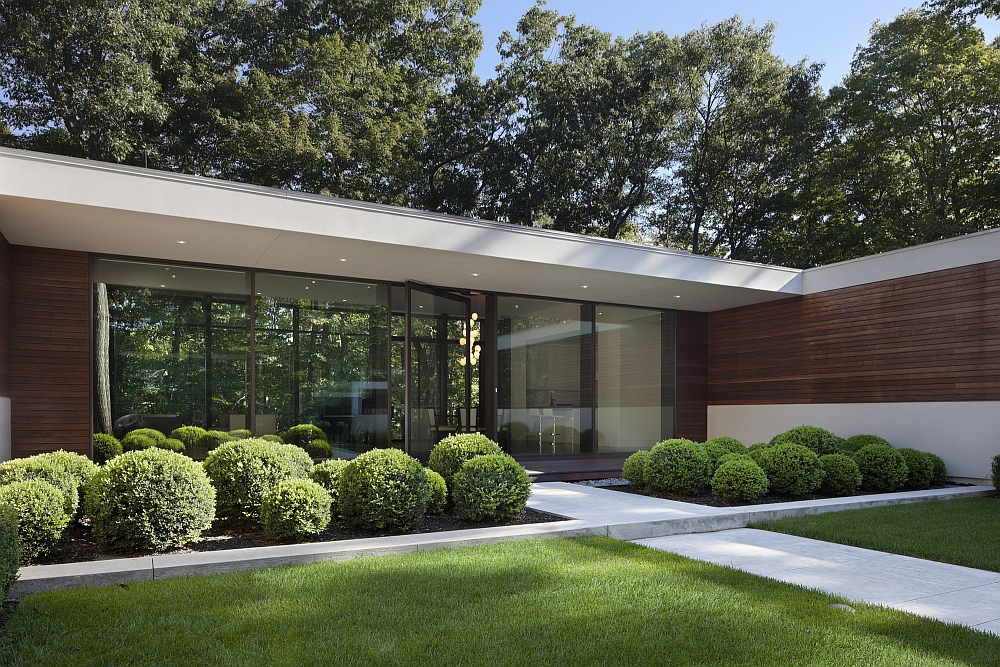 Large glass windows take the greenery inside the house visually