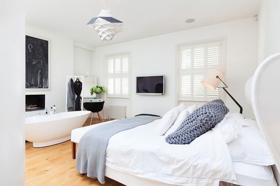 Luxurious bedroom with a standalone bathtub next to the fireplace