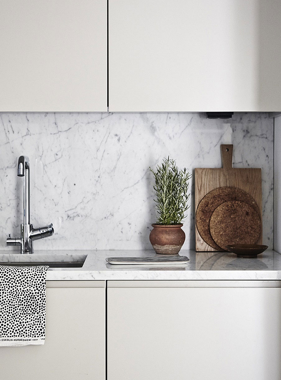 Marble backsplash in the kitchen adds elegance to the Scandinavian design