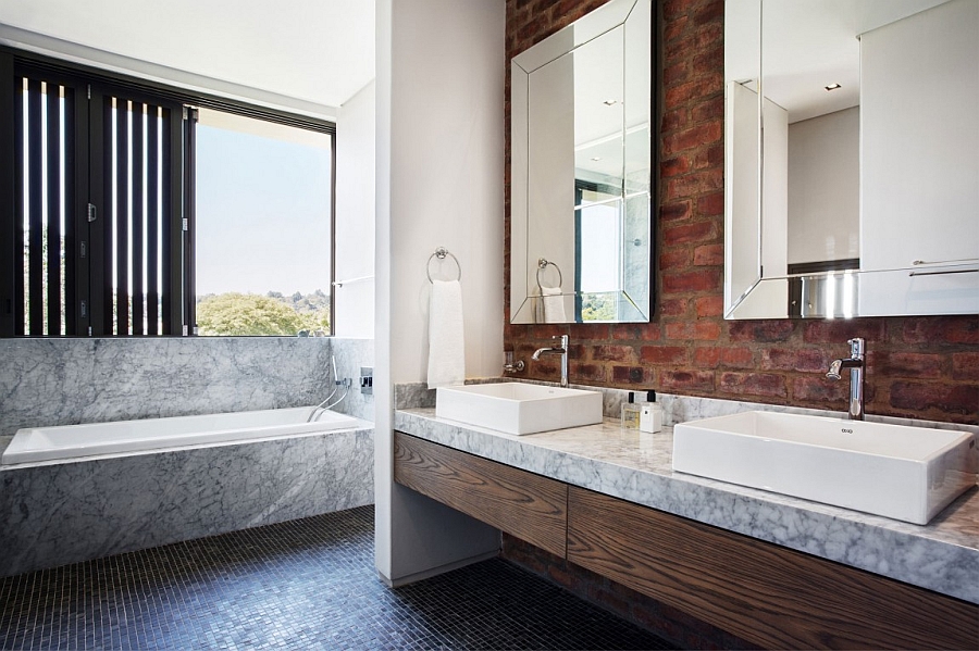 Modern bathroom with marble bathtub and a brick wall