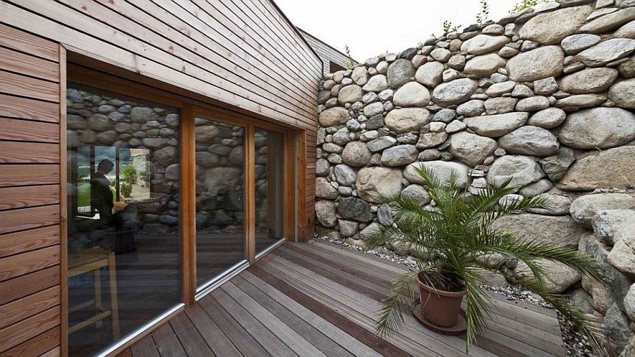 Natural stone wall of the house gives the facade textural contrast