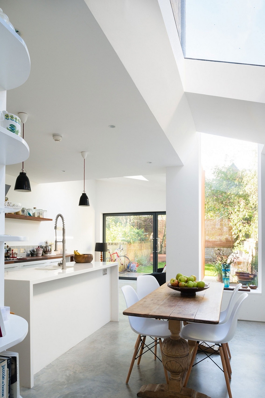 Natural wooden table and Eames chairs shape the small dining nook