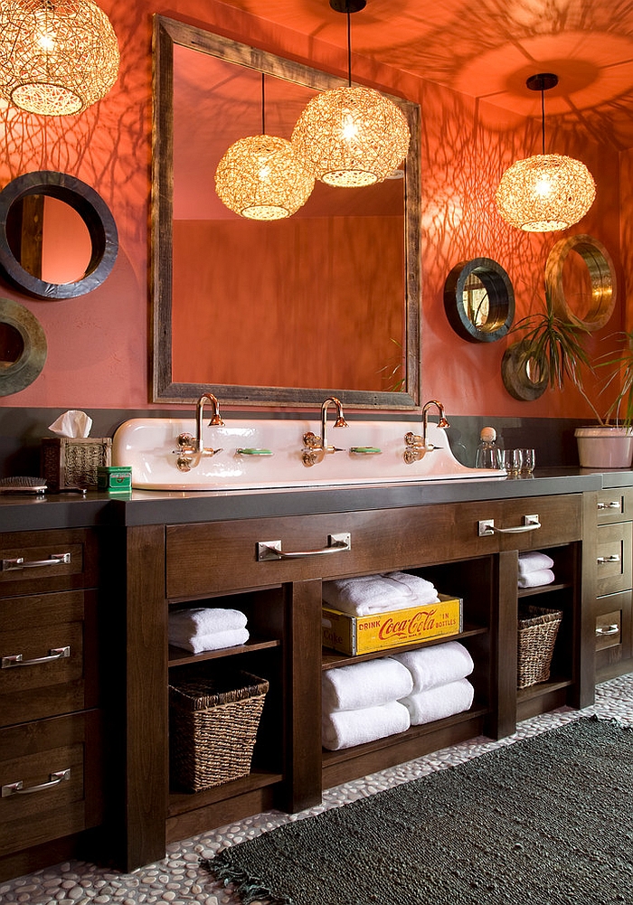 Pendant lights elevate the appeal of the rustic bathroom in orange [Design: Studio 80 Interior Design]