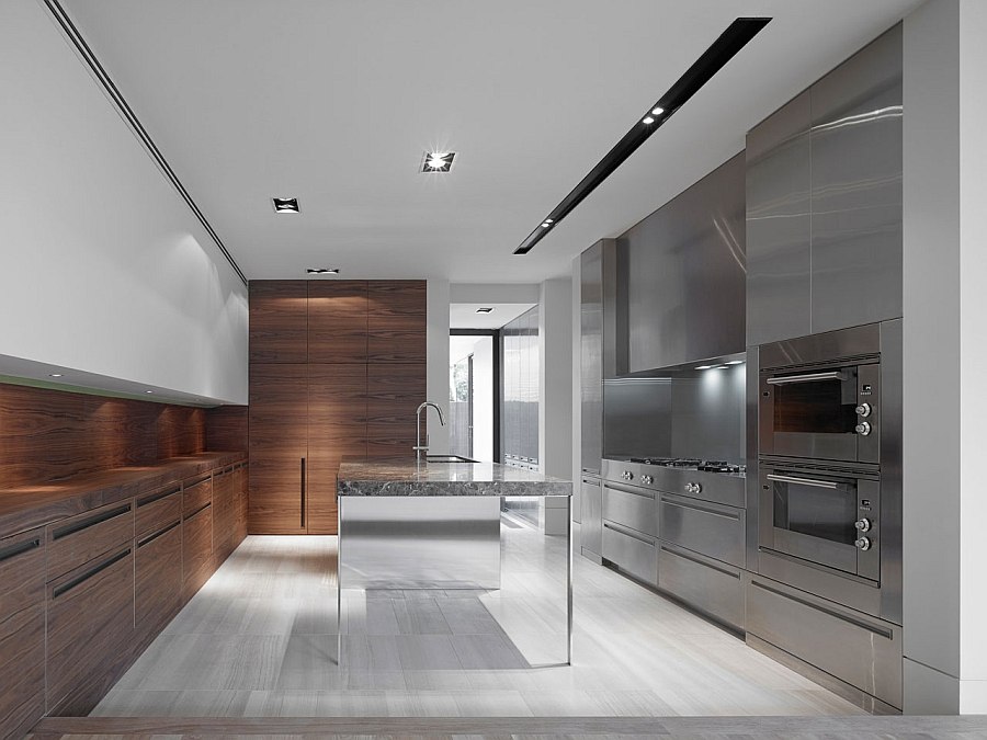 Reflective surfaces and wooden counters add textural contrast to the sleek kitchen