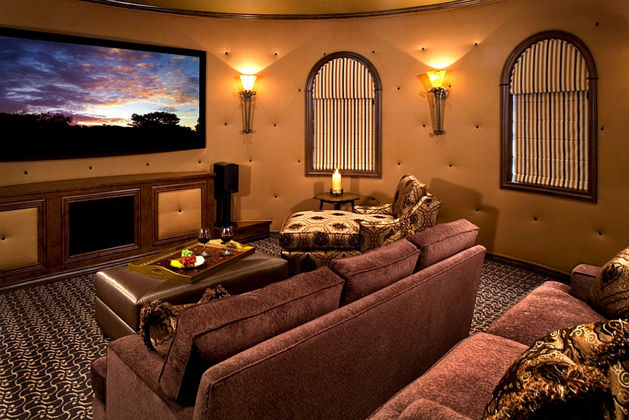 Round tufted walls and lovely lighting give the home theater a cozy, warm vibe