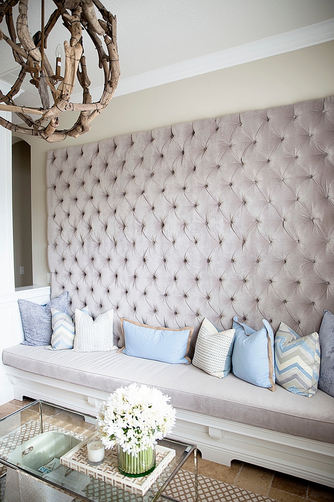 Tufted wall and bench provide smart seating for the living room [Design: Steele Street Studios]