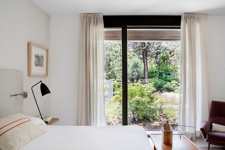 White sheer curtains improve the insulation of the bedroom even while letting in naural light