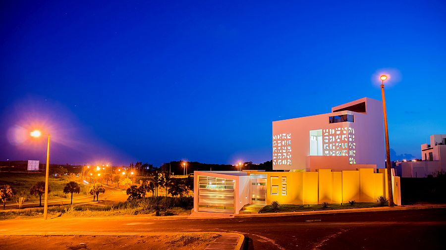 Brilliant lighting and a pop of Orange enliven the exterior of the house