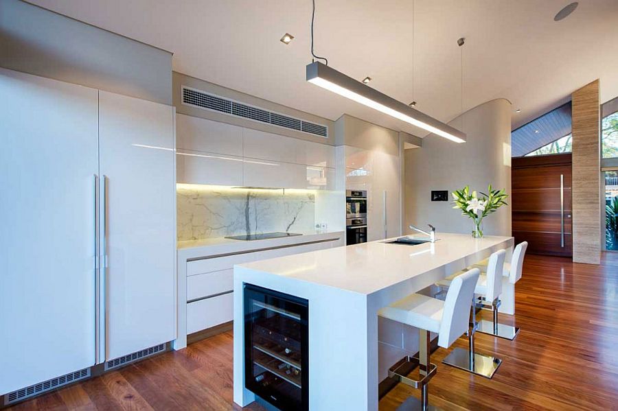 Contemporary kitchen in white with smart island and marble backsplash