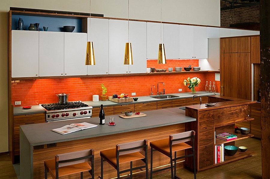 Orange backsplash and bold metallic pendants breathe life into the kitchen