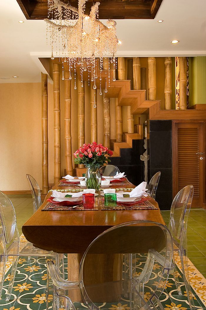 Staircase with bamboo railing makes up the backdrop for the eclectic dining room [Design: Iwan Sastrawiguna Interior Design]