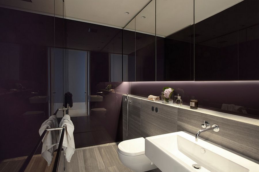 Lighting steals the show in this dark, purple bathroom