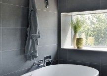 Standalone-bathtub-in-white-in-a-bathroom-with-gray-wall-tiles-217x155
