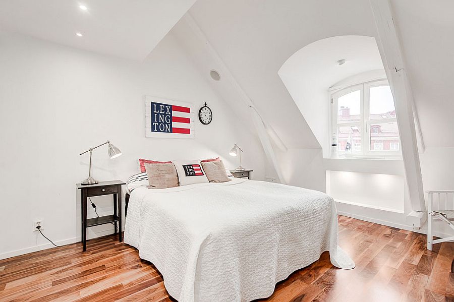 Stylish Scandinavian style attic bedroom in white with wooden flooring