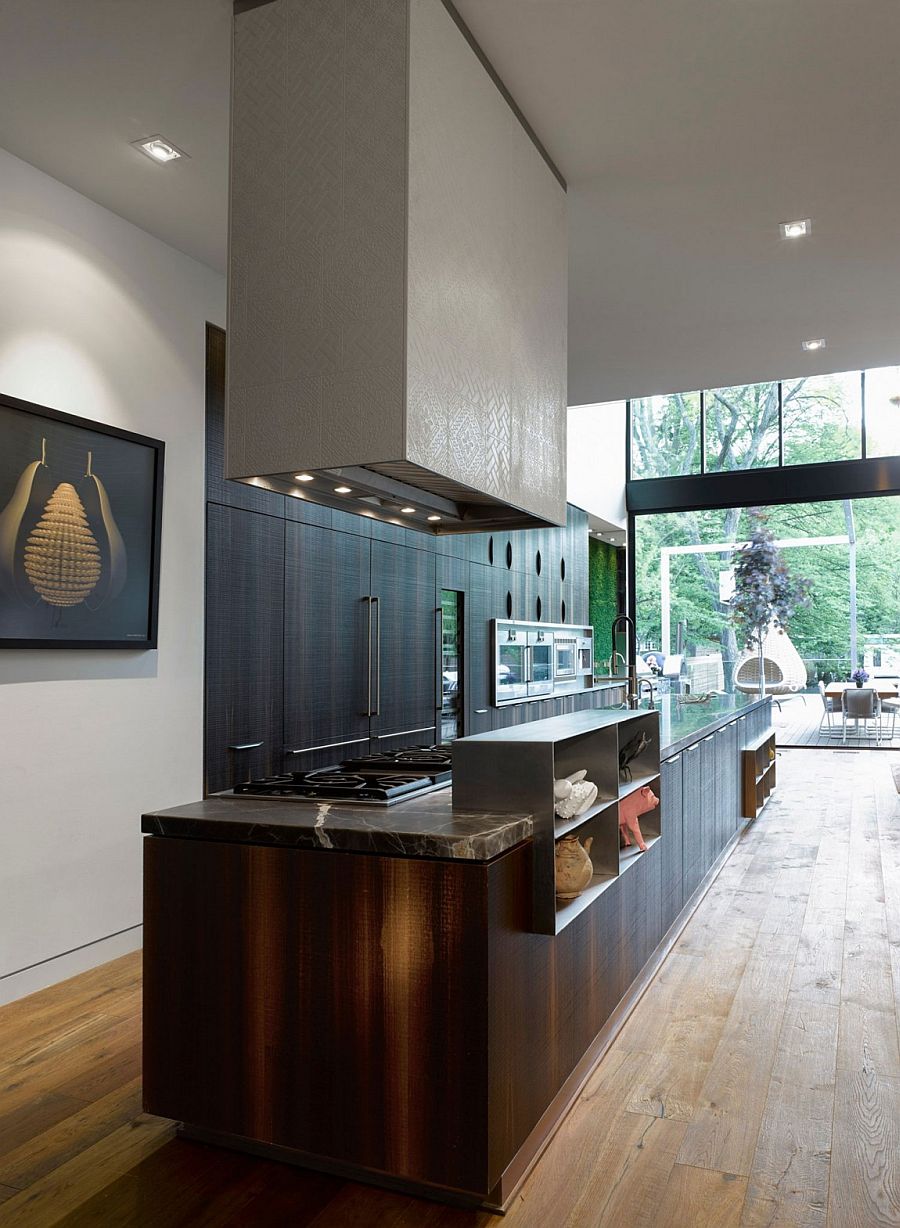 Kitchen island that is seamlessly connected with the deck outside using large glass doors