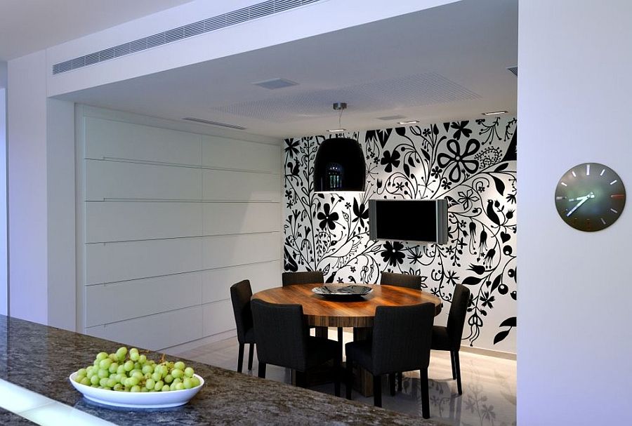 Lighting adds to the appeal of the striking black and white wallpapere in the dining room