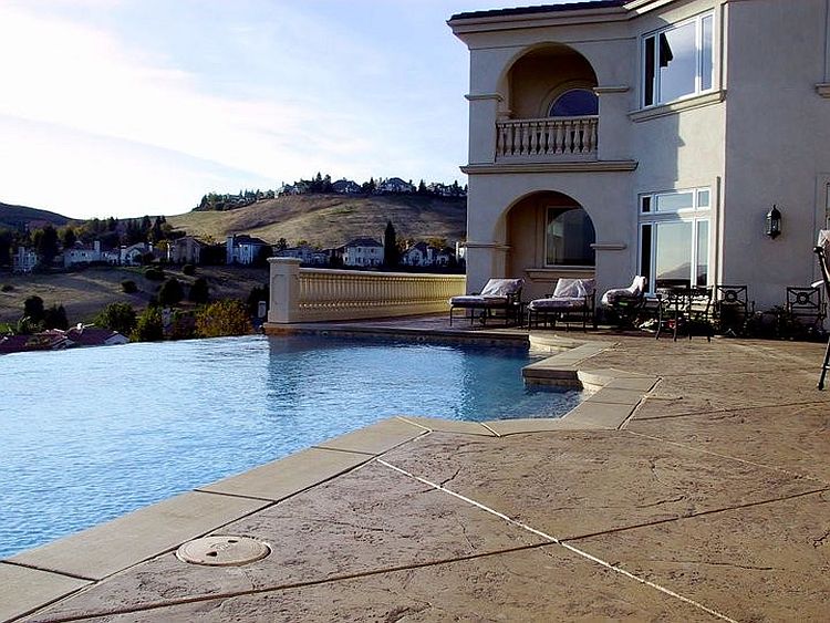 Mediterranean style pool area with stamped concrete deck