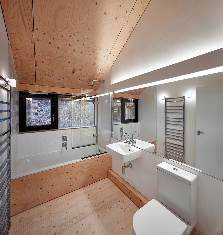 Neutral color scheme and slanted wooden ceiling inside the modern bath