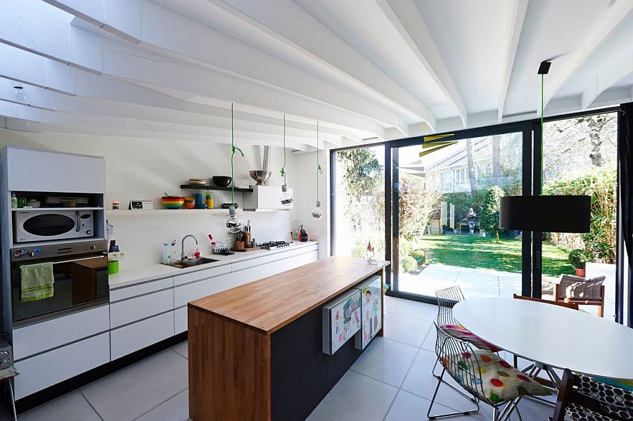 Small kitchen and dining area connected with the simple backyard using framed glass doors