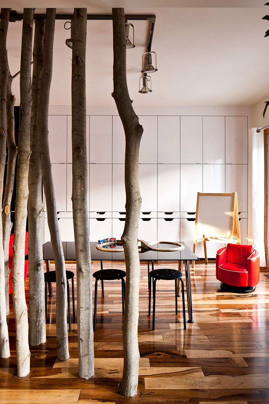 Use of tree trunks to create a natural, whimsical partition in the dining area