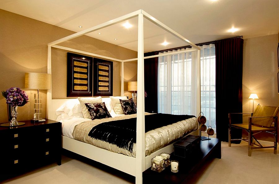 Wallpapered walls in gold and black decor and throws give the master bedroom a luxurious look