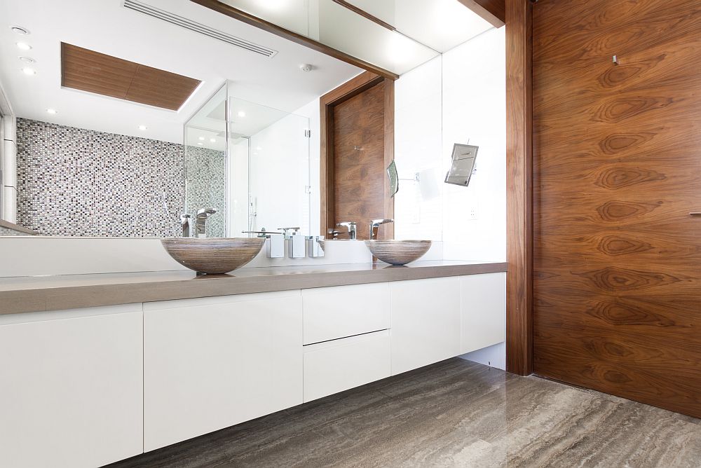 Wooden accent wall and vanity in white with twin sinks inside the bathroom