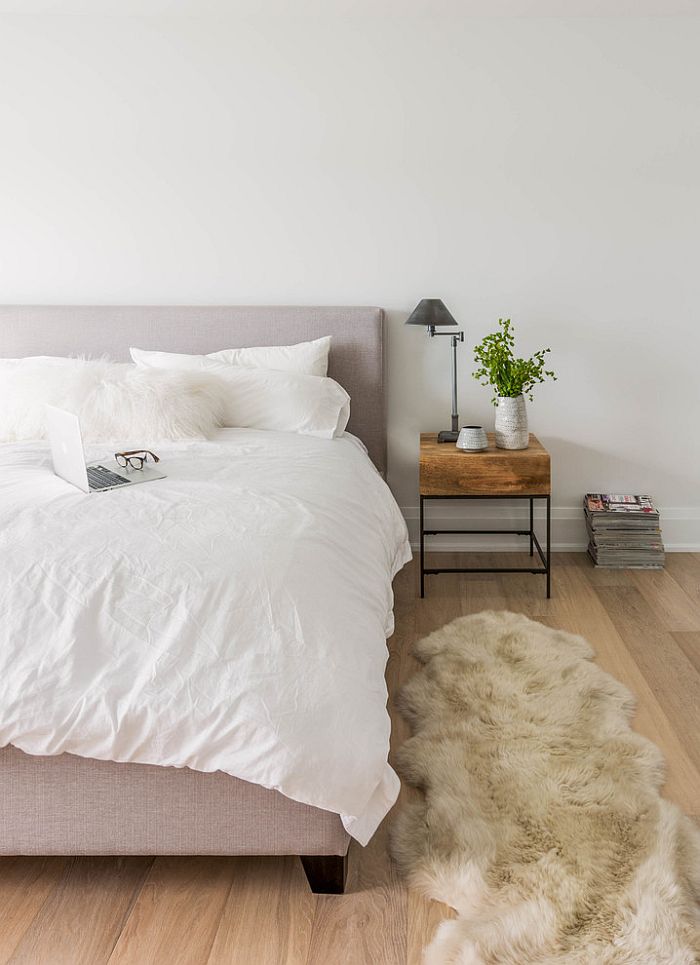 Bedside table and plush rug bring warmth to the cool bedroom