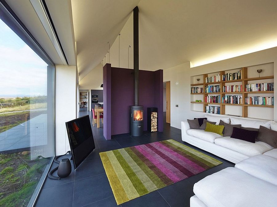 Bright purple accent wall separates the living area from the kitchen and dining spaces