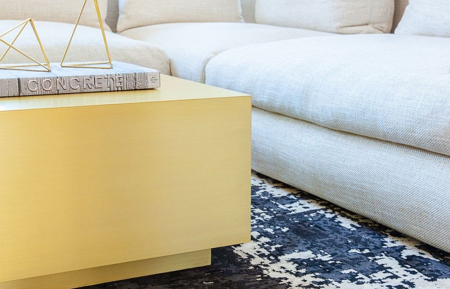 Chic rug,plush couch and brass tinged coffee table in the lving room