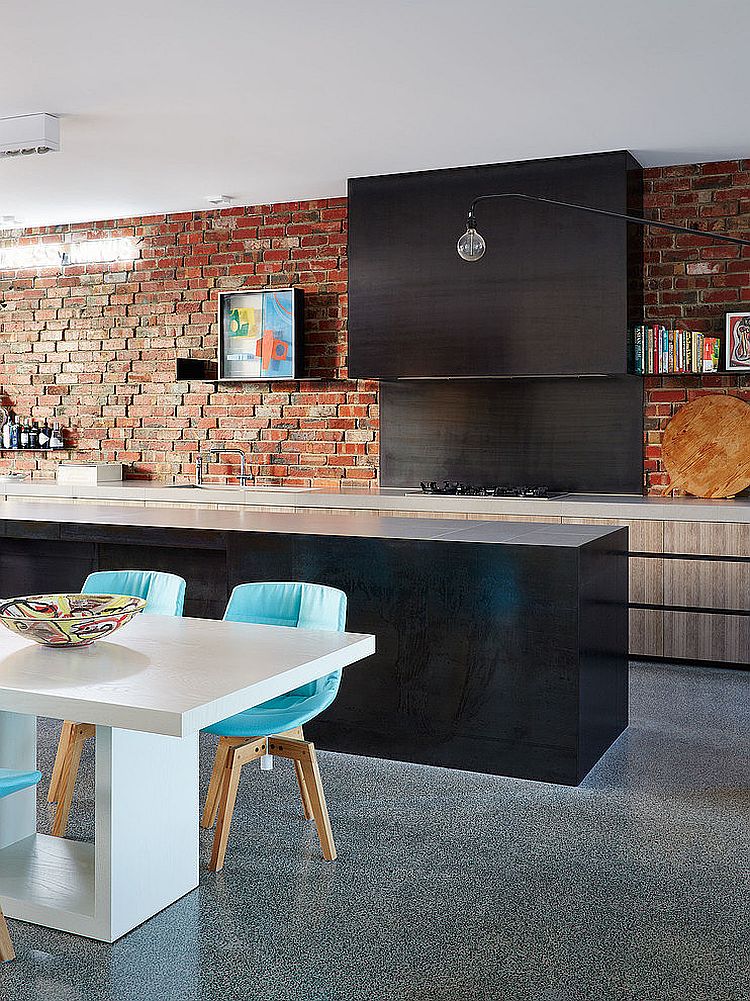 Contemporary kitche with a charming brick wall, sleek black island and dining area