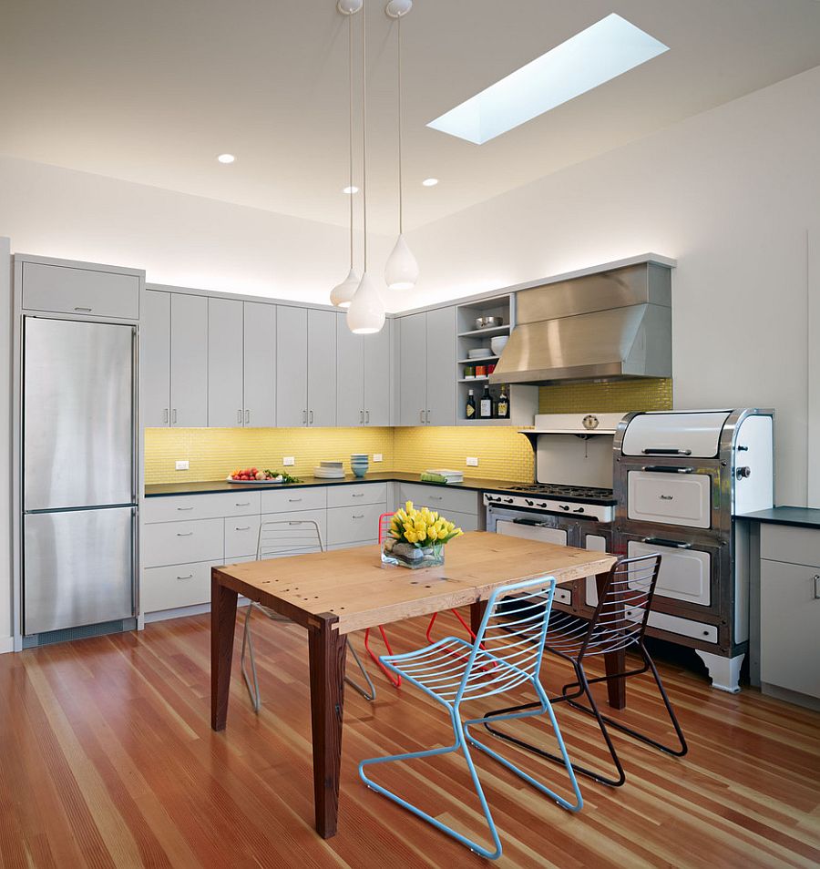 Contemporary kitchen with gray cabinets and yellow backsplash and a skylight