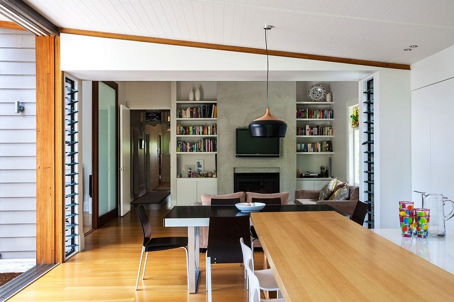 Dining and sitting area with large bookshelf and concrete walls