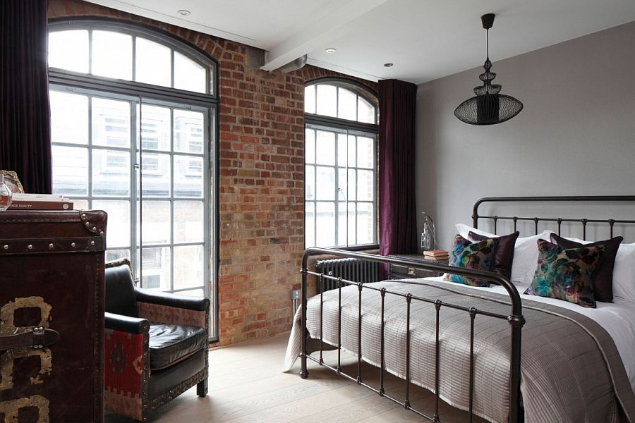 Elegant bedroom with brick wall and wrought iron bed frame