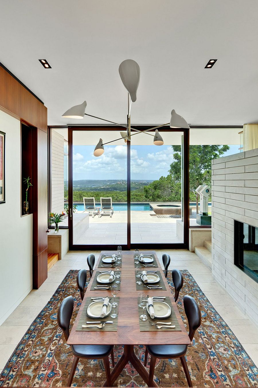 Formal dining area of the Lake View Residence connected visually with the pool deck outside